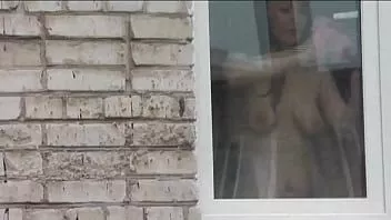 播放 在公共场合赤身裸体。裸体。户外的。外部。丈夫性感的弗里娜正在从车窗监视她的妹妹，当时她洗公寓的窗户，没有内裤和胸罩。